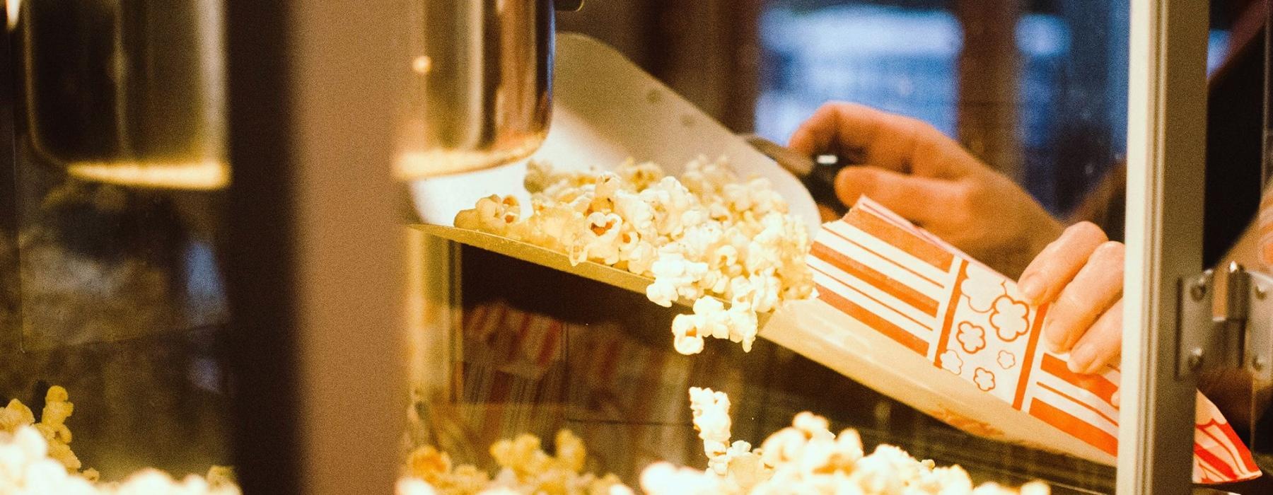 a person pouring popcorn into a container